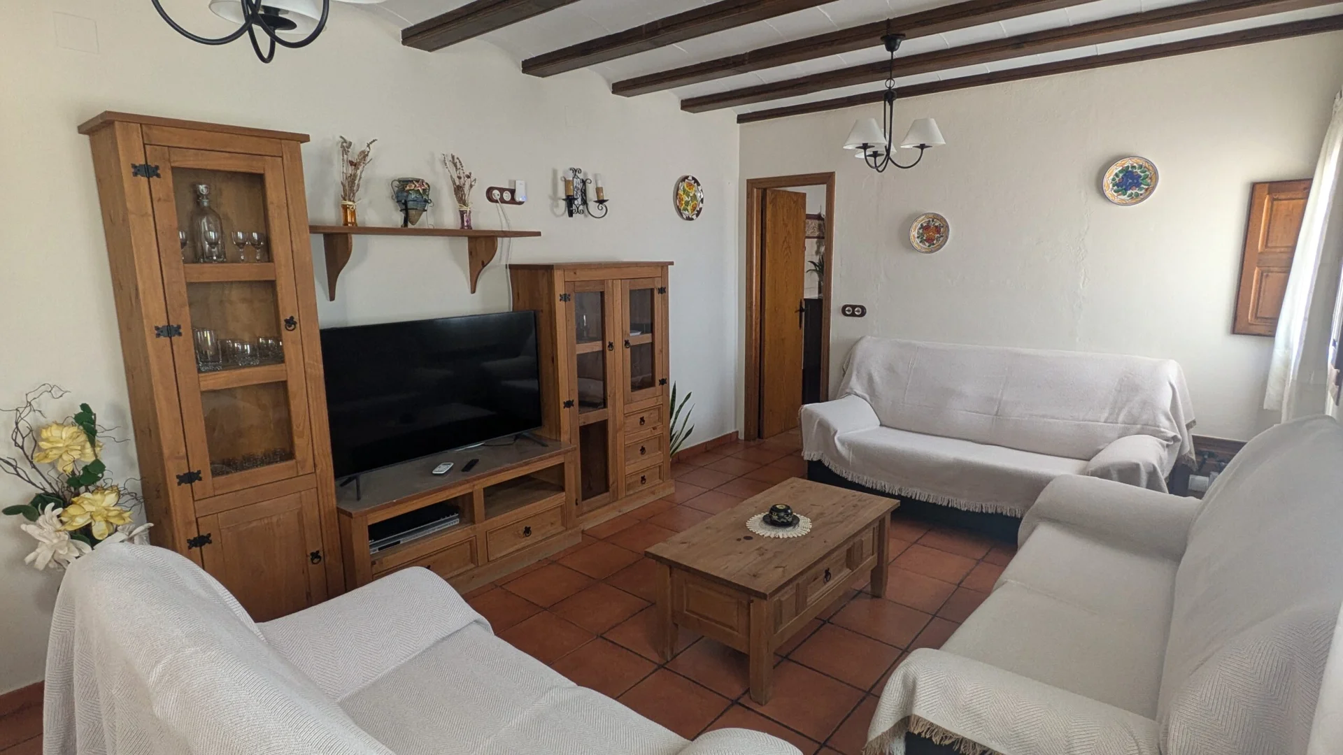 Salón de Mas de Cervera con sofás, mesa de centro y muebles de madera